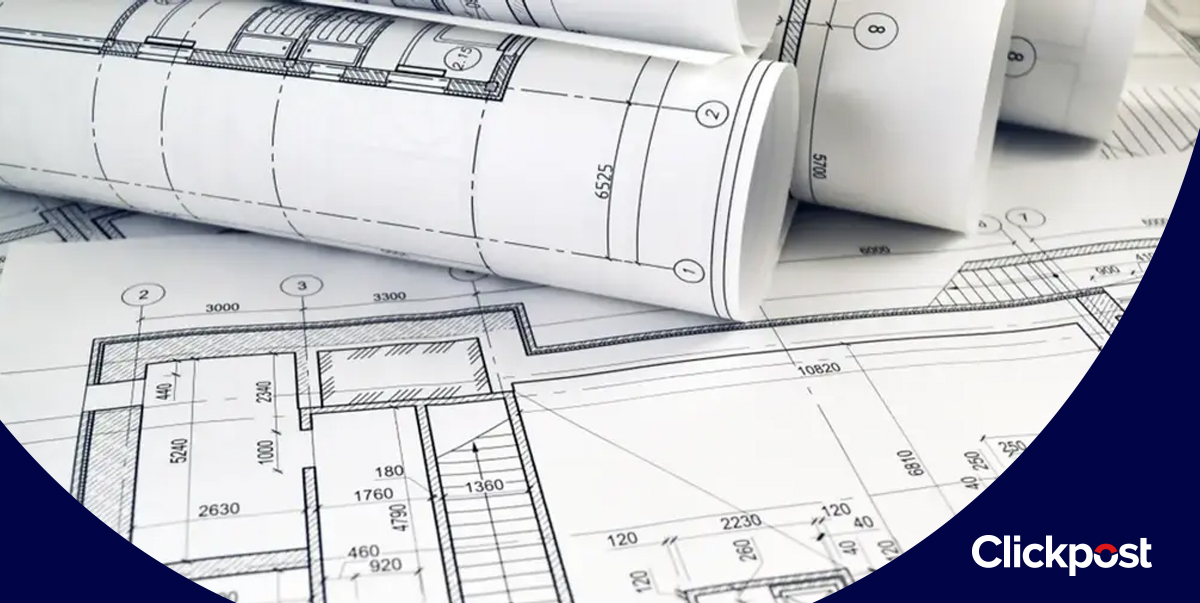 Rolled and flat printed plans laid out for review in a workspace